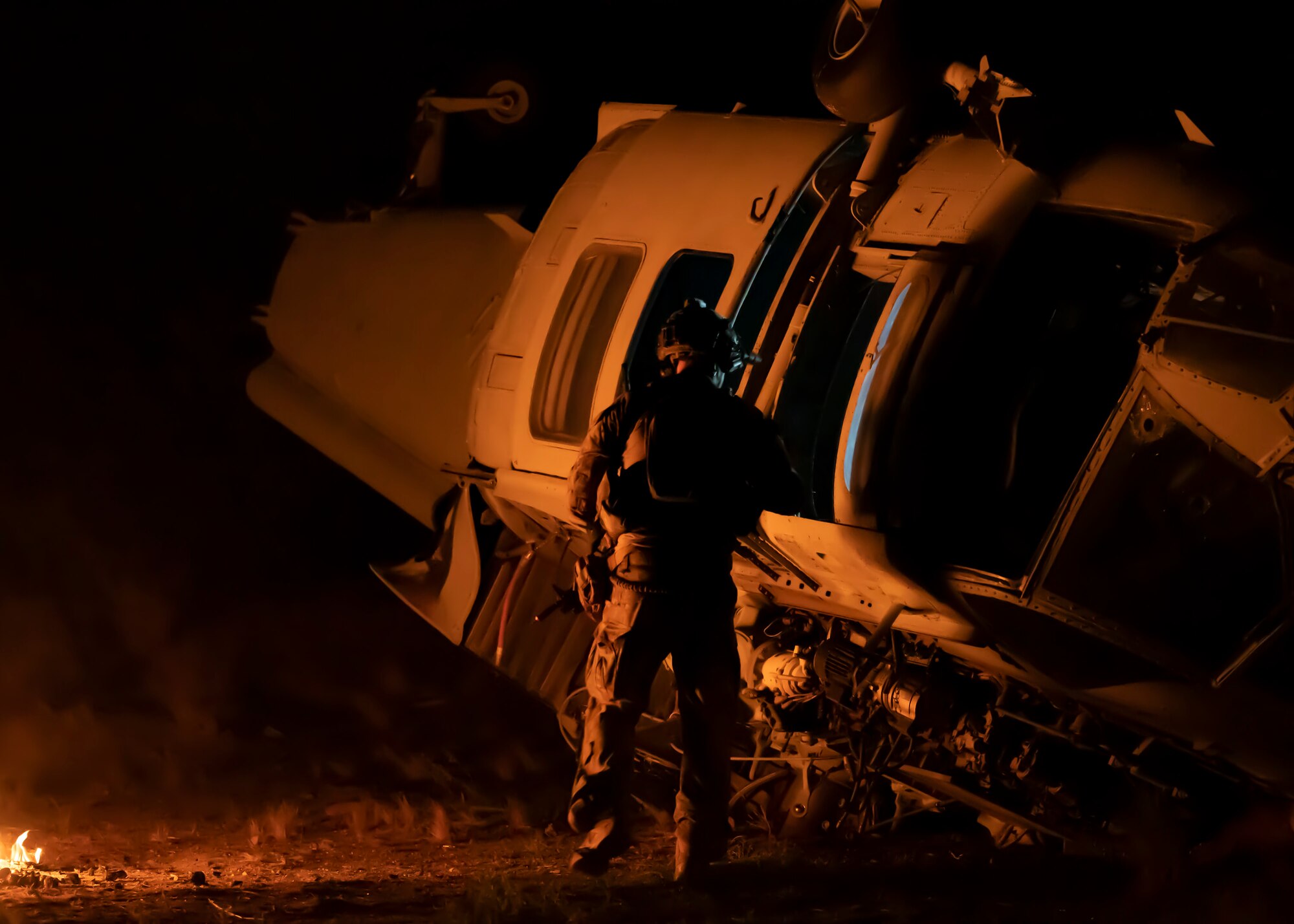 A U.S. Airman, training with the 68th Rescue Squadron, looks inside a simulated aircraft crash at Davis-Monthan Air Force Base, Ariz., Aug. 24, 2023. The Airman was searching for simulated casualties in need of rescue during a training scenario. (U.S. Air Force photo by Airman 1st Class William Finn V)