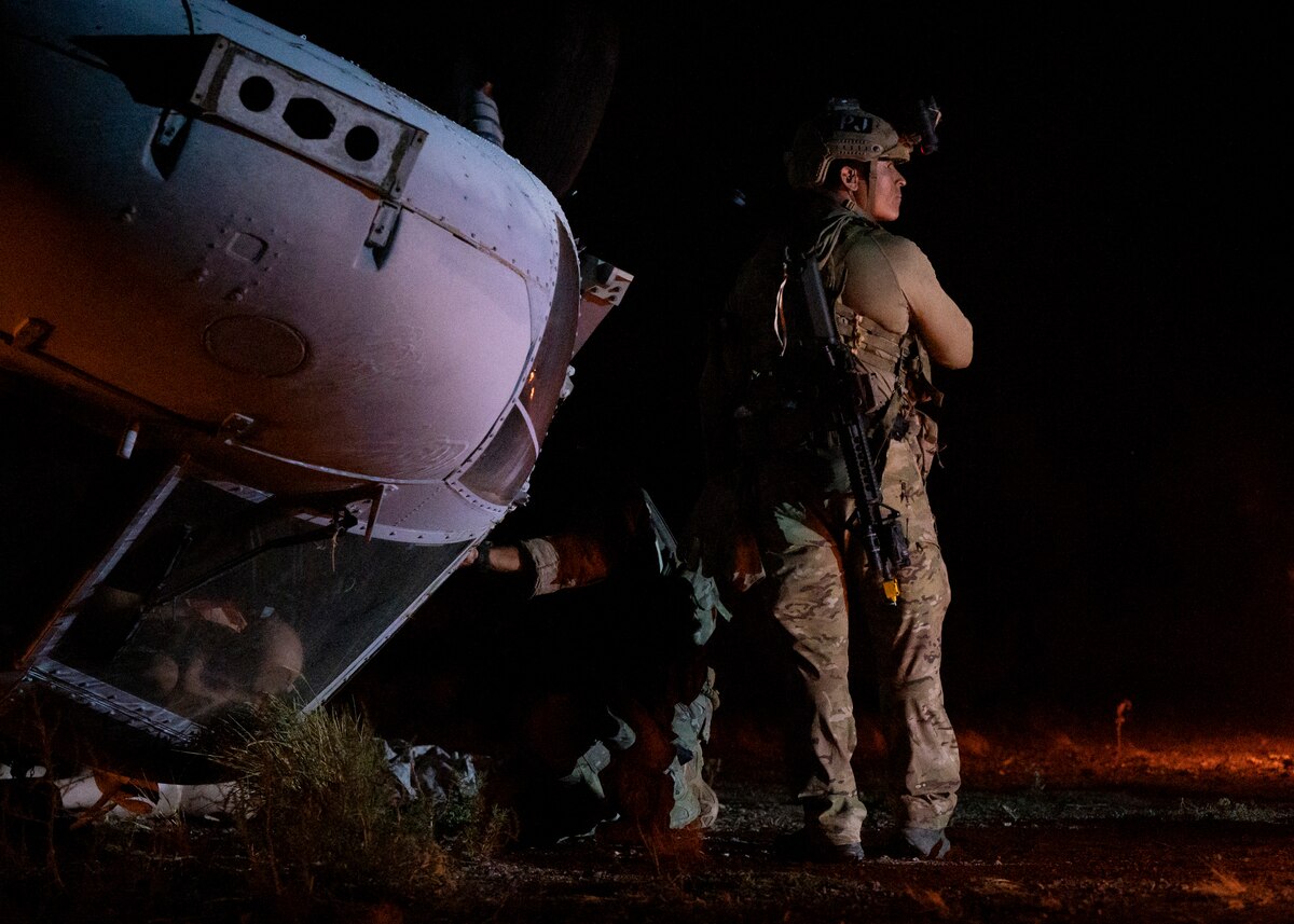 U.S. Airmen, training with the 68th Rescue Squadron, search a simulated aircraft crash for casualties at Davis-Monthan Air Force Base, Ariz., Aug. 24, 2023. The Airmen rescued casualties from several simulated crash sites all while engaging with opposing forces during a training scenario. (U.S. Air Force photo by Airman 1st Class William Finn V)
