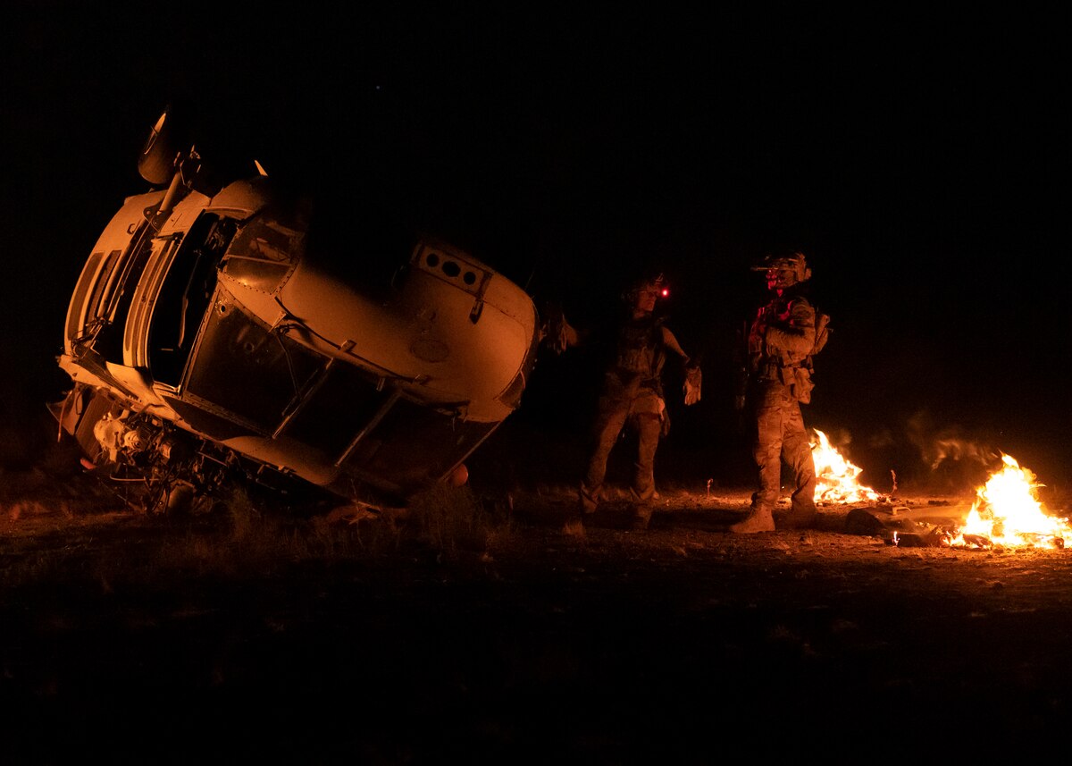 U.S. Airmen, training with the 68th Rescue Squadron, assess a simulated aircraft crash site at Davis-Monthan Air Force Base, Ariz., Aug. 24, 2023. The Airmen engaged with opposing forces shortly upon arriving at the site. (U.S. Air Force photo by Airman 1st Class William Finn V)