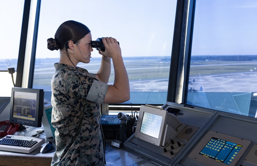 U.S. Marine Corps Cpl. Karli Treese, an air traffic controller attached to Headquarters and Headquarters Squadron, Marine Corps Air Station (MCAS) New River, looks through binoculars in the air traffic control tower on MCAS New River, in Jacksonville, North Carolina, Sept. 25, 2023. Treese, the recipient of this month's MCAS New River Go-Getter award, enlisted in the Marine Corps in 2020 from Kansas City, Missouri. (U.S. Marine Corps photo by Lance Cpl. Loriann Dauscher)