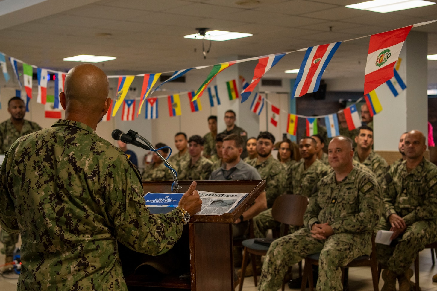 Command Master Chief Rafael Barney, Naval Support Activity Souda Bay, talks about his cultural heritage during a National Hispanic Heritage Month Celebration held by the Souda Bay Multicultural Committee in The Anchor on Sept. 28, 2023.