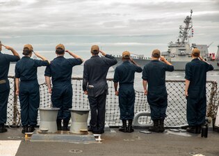 Sailors aboard USS John Finn (DDG 113) render honors to USS Rafael Peralta (DDG 115).