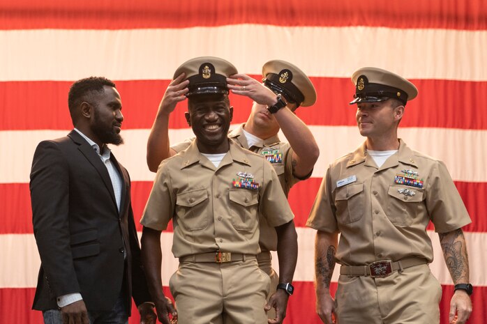 Chief Logistics Specialist Paul Bamgbala receives his combination cover during a chief petty officer pinning ceremony at Naval Base Kitsap-Bremerton, Washington Sept. 29, 2023. The rank of chief petty officer was officially established April 1, 1893, and holding the title "Chief" means a Sailor has achieved senior non-commissioned officer status. (U.S. Navy photo by Mass Communication Specialist 3rd Class Sophia H. Bumps)