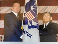 "Change of Watch" ceremony at USCG HQ when Secretary of the Department of Transportation Norman Mineta and the Secretary of the "new" Department of Homeland Security Tom Ridge hold the Coast Guard ensign during a ceremony signaling the service's move to the new cabinet level department on 25 February 2003.