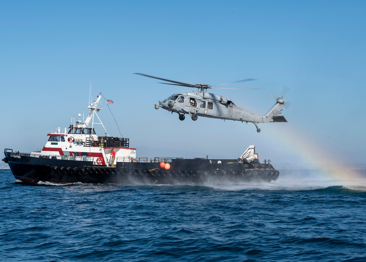 U.S. Airmen, training with the 68th Rescue Squadron, prepare to lower themselves from a MH-60 Seahawk onto a tugboat to rescue simulated casualties near San Diego, Calif., Sept. 6, 2023. The Airmen were required to use two MH-60S’ to exfiltrate the casualties. (U.S. Air Force photo by Airman 1st  Class William Finn V)
