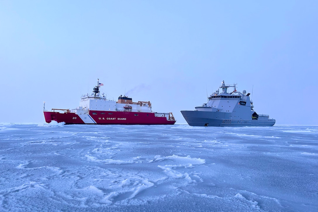 Two ships sail in formation while transiting icy waters.