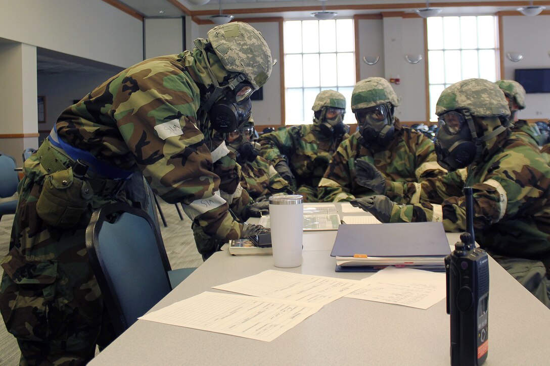 Airmen of the 127th Force Support Squadron review operating instructions for their squadron while wearing Mission Oriented Protective Posture (MOPP) gear during an exercise at Selfridge Air National Guard Base, Mich., Sept. 10, 2023.