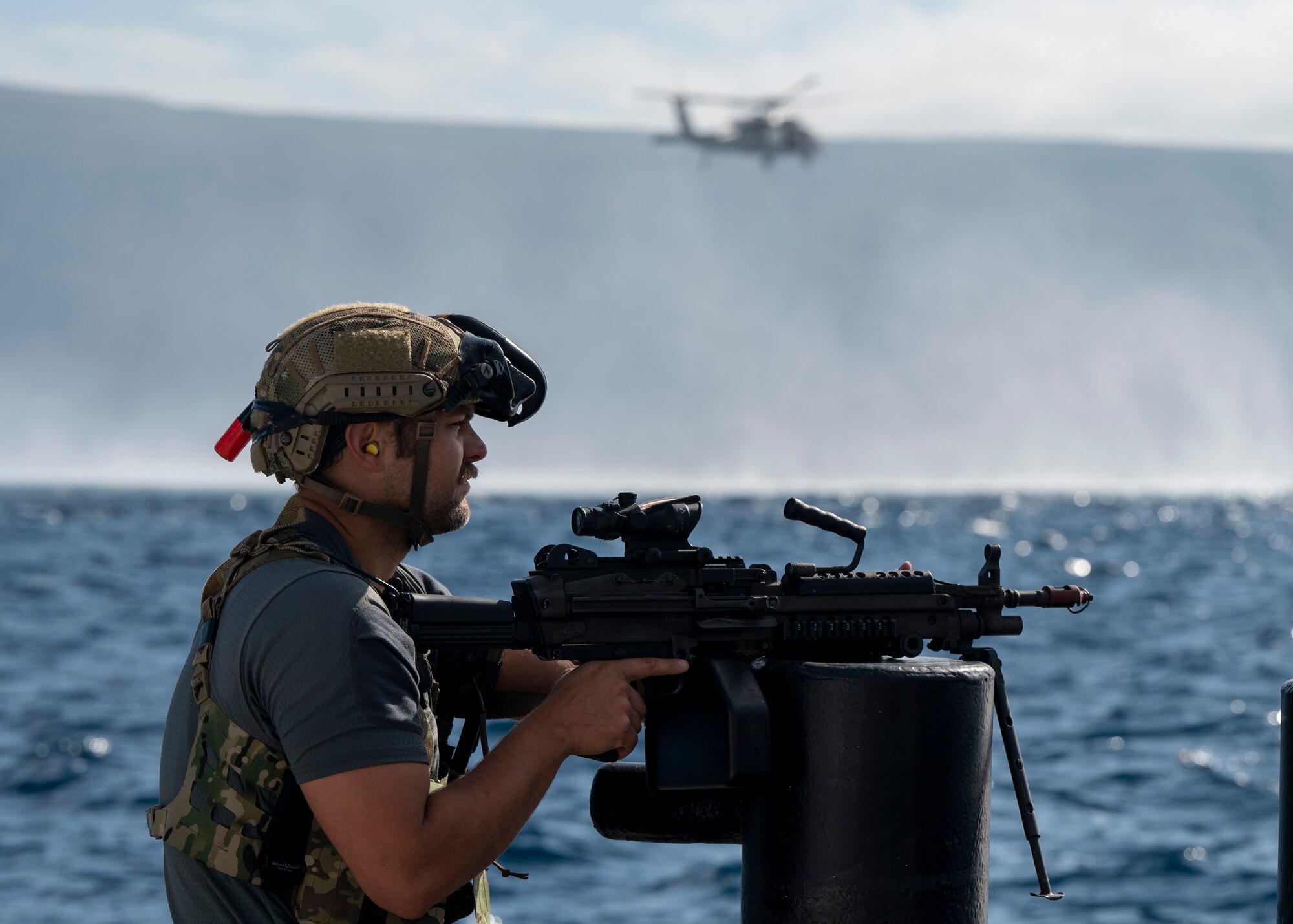 A U.S. Airman, training with the 68th Rescue Squadron, keeps watch for simulated opposition forces off the coast of Calif., Sept. 13, 2023. The Airman engaged with multiple forms of simulated OPFOR throughout the training. (U.S. Air Force photo by Airman 1st Class William Finn V)