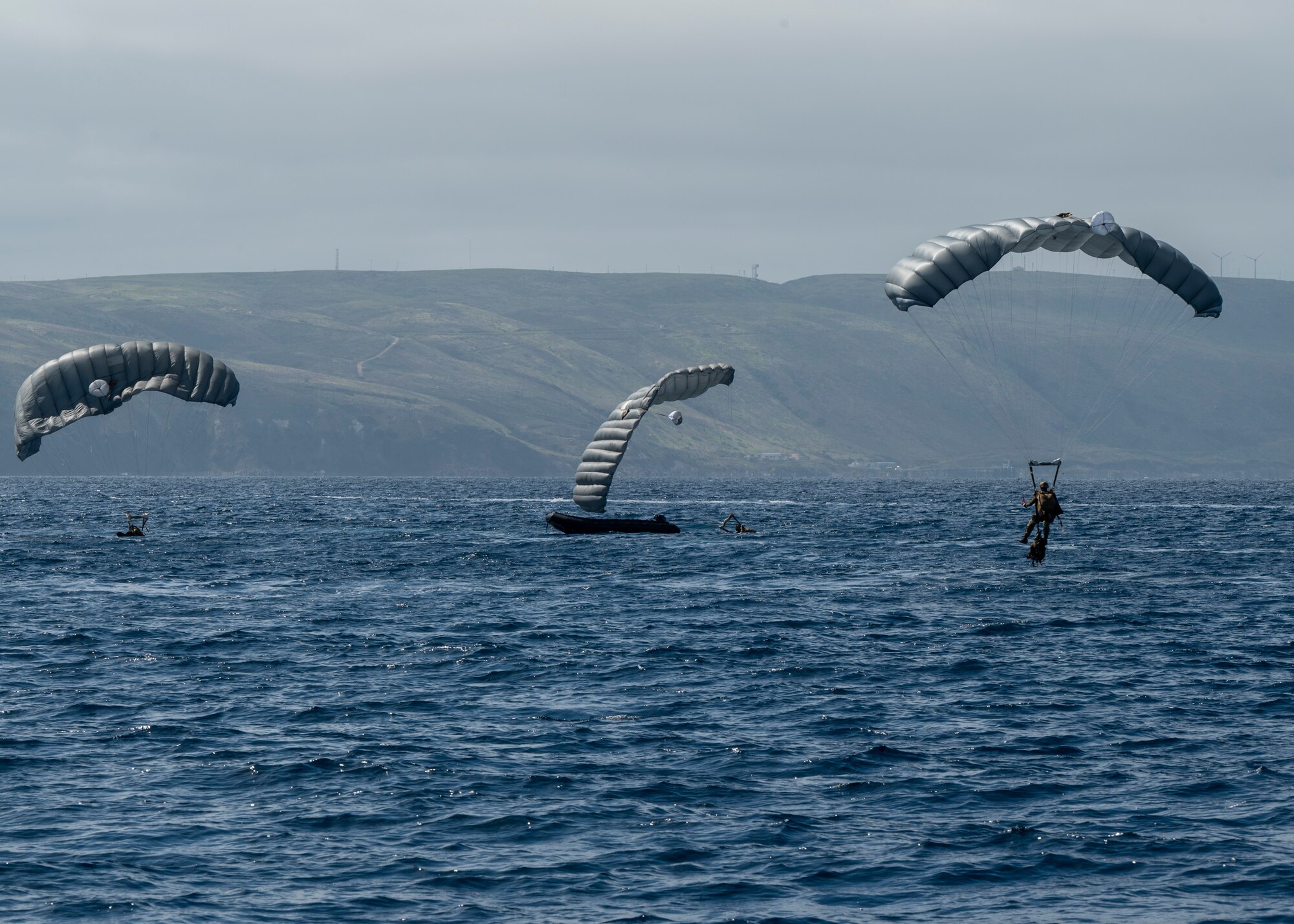 U.S. Airmen, training with the 68th Rescue Squadron, parachute into a drop zone off the coast of Calif., Sept. 13, 2023. The Airmen jumped into the drop zone in two groupings of members, before boarding a Rigged Alternate Method Boat. (U.S. Air Force photo by Airman 1st Class William Finn V)