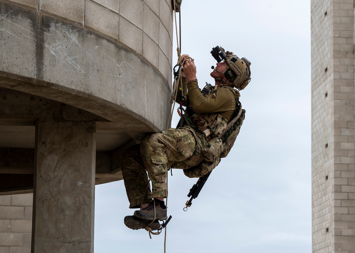A U.S. Airman, training with the 68th Rescue Squadron, climbs up a balcony of a building at an UNDISCLOSED LOCATION, Calif., Sept. 17, 2023. The Airman searched for and rescued simulated casualties from the second floor of the building. (U.S. Air Force photo by Airman 1st Class William Finn V)