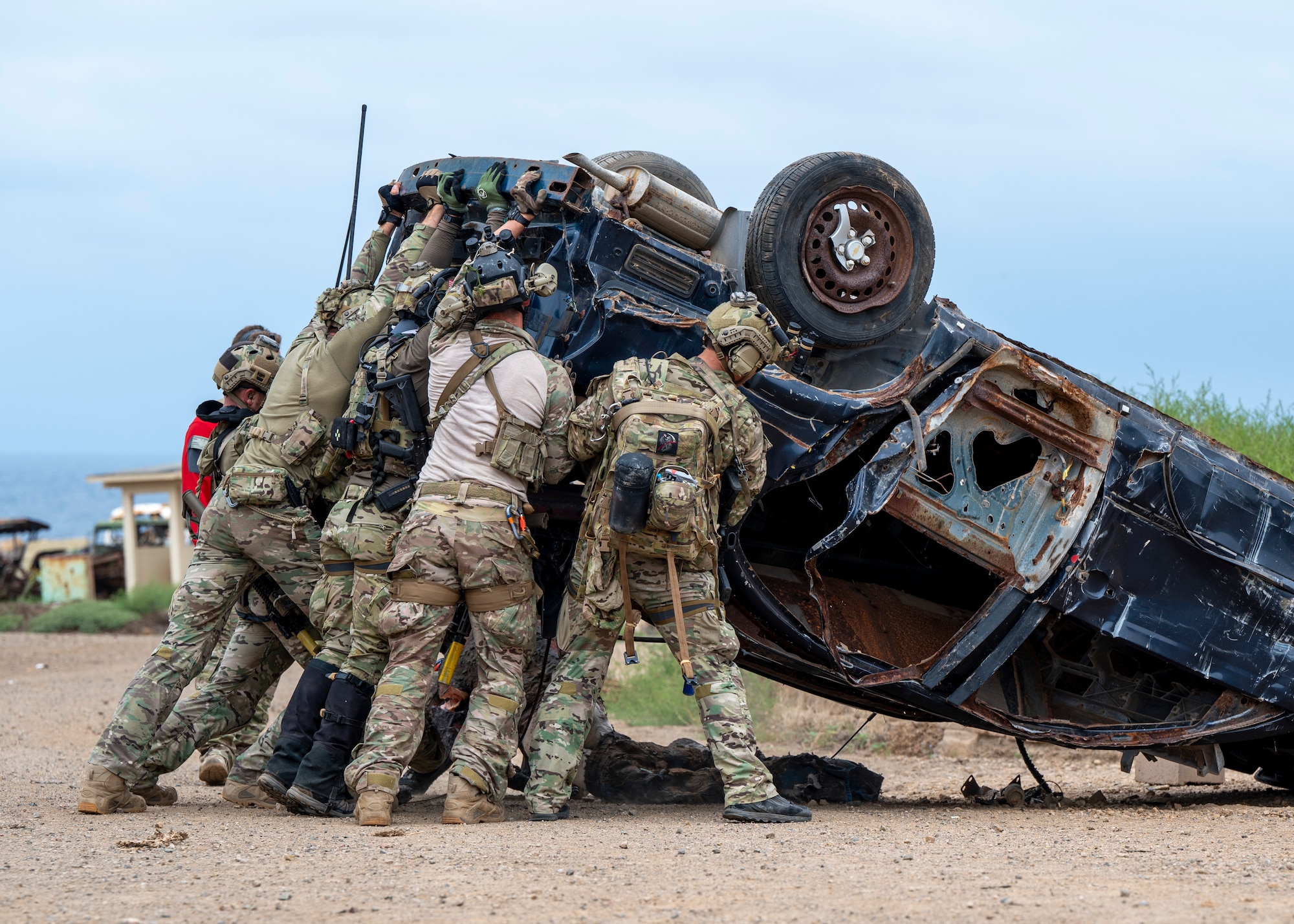 U.S. Airmen, training with the 68th Rescue Squadron, rescue a simulated casualty from beneath a car at an UNDISCLOSED LOCATION, Calif., Sept. 17, 2023. The Airmen worked as a team to lift the car while one of their team members removed the simulated casualty from underneath. (U.S. Air Force photo by Airman 1st Class William Finn V)