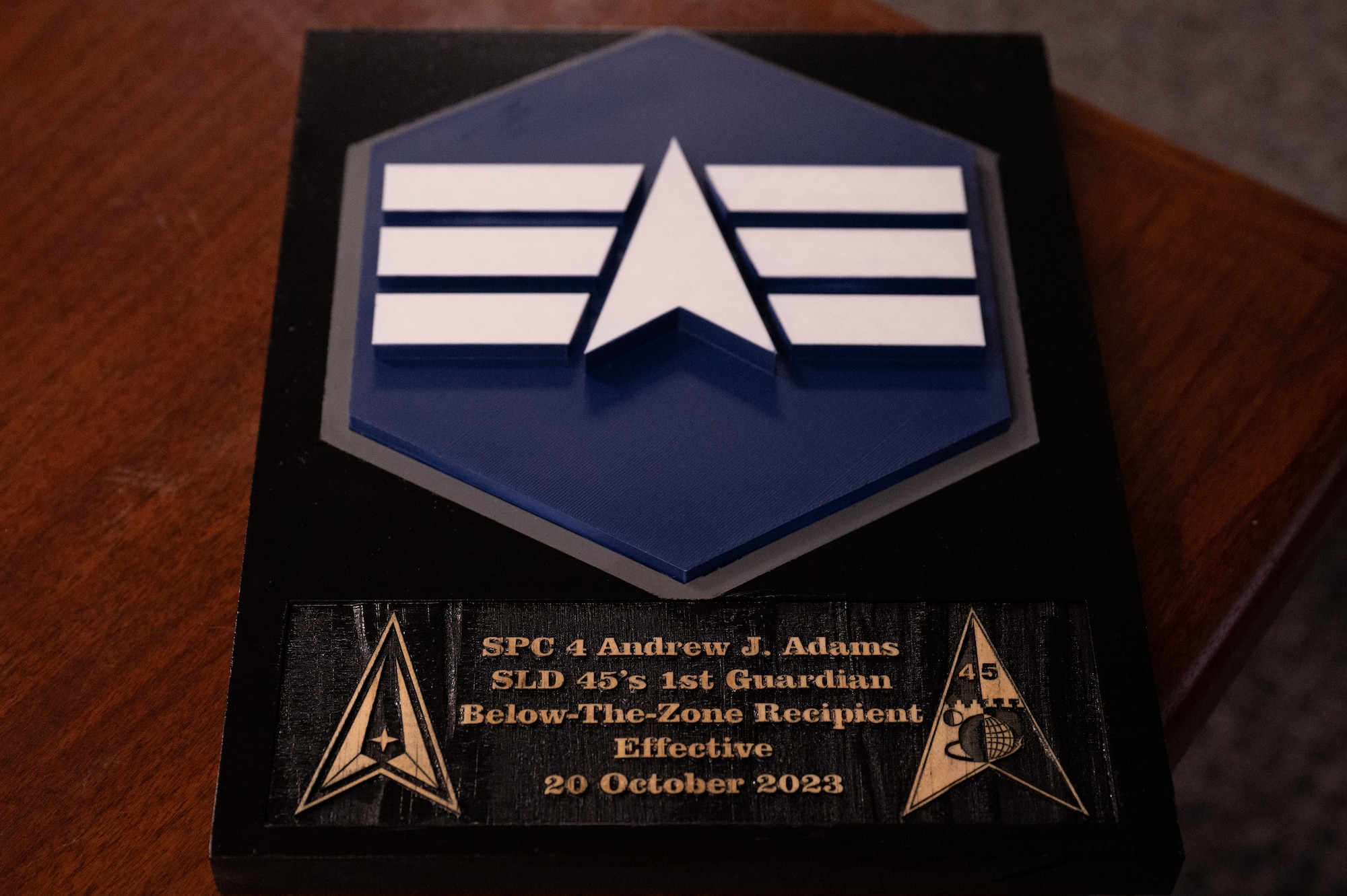 Placard awarded to U.S. Space Force Andrew Adams, 645th Cyberspace Squadron defensive cyber operator for achieving Below-the-Zone promotion at Patrick Space Force Base, Florida, Oct. 2, 2023. Specialist Adams was selected for Below-the-Zone, a competitive selection that allows those with the rank of Airman 1st Class/Specialist 3 to achieve Senior Airman/Specialist 4, six months ahead of the standard promotion date. (U.S. Space Force photo by Amn Collin Wesson.)