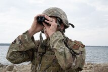 Tech. Sgt. Jacob Sober, 5th Civil Engineer Squadron water and fuel systems maintenance craftsman, scans the surrounding area at Douglass Creek campgrounds, North Dakota, Sept. 23, 2023. Sober used binoculars to secure the area while his teammates procured a safe water source during an Agile Combat Employment exercise.