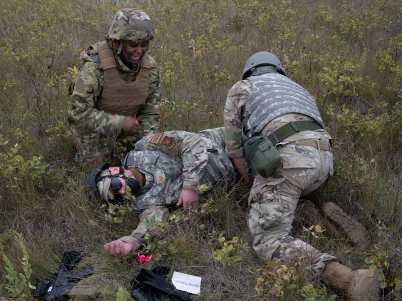 Airmen assigned to the 5th Civil Engineer Squadron perform Tactical Combat Casualty Care on a simulated wounded teammate at Douglass Creek campgrounds, North Dakota, Sept. 23, 2023. The Airmen participated in an Agile Combat Employment exercise which emphasized adaptability and effective utilization of multi-capable Airmen.