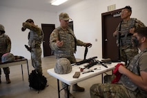 Airmen assigned to the 5th Civil Engineer Squadron (CES) clean weapons at Douglass Creek campgrounds, North Dakota, Sept. 23, 2023. 5th CES Airmen participated in an exercise emphasizing Agile Combat Employment, or ACE, a concept which was created to disperse small groups of multi-capable Airmen to remote bases.