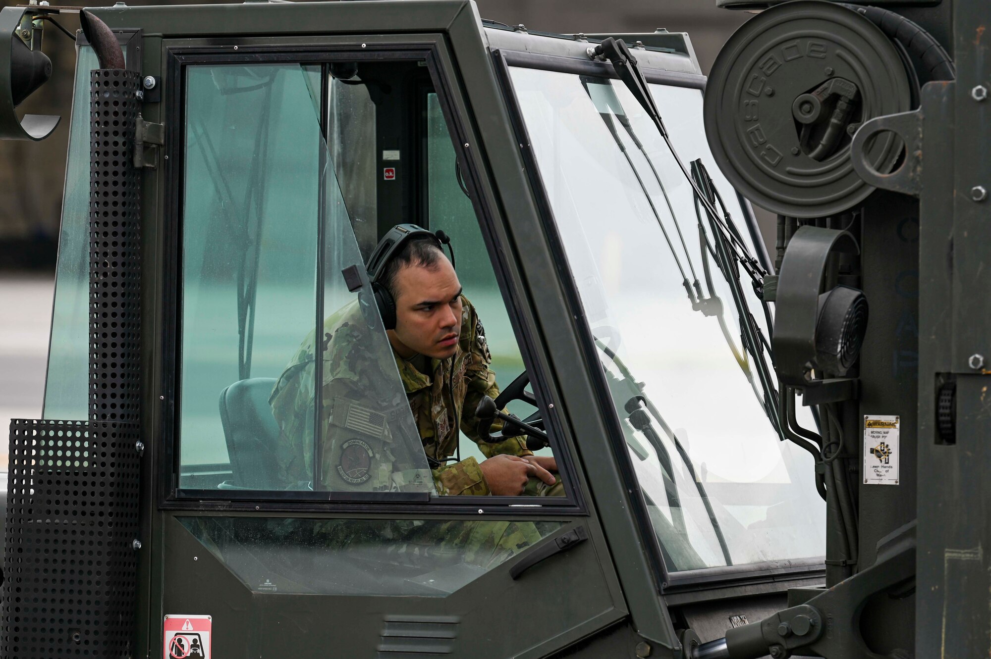 An Airman drives a forklift loaded with cargo