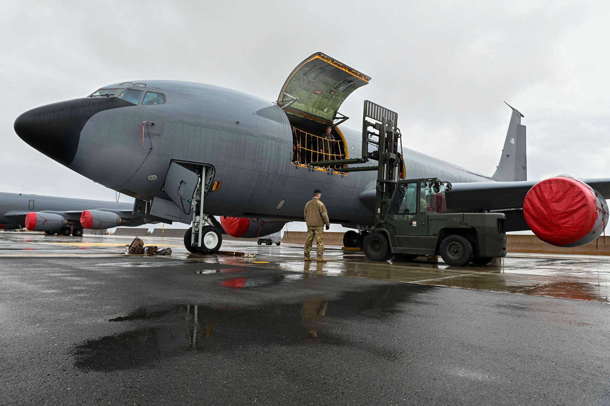 Airmen load cargo into a KC-135 Stratotanker using a forklift