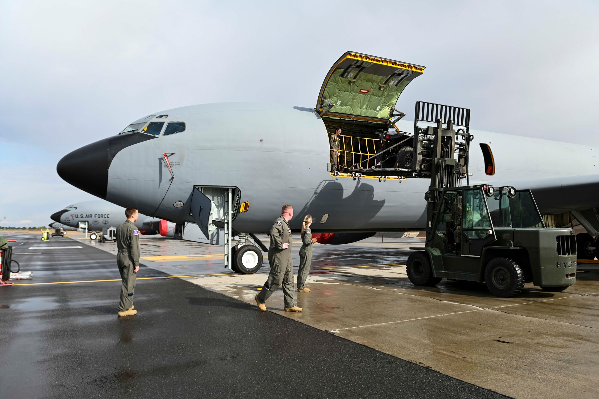 Airmen guide cargo into a KC-135 Stratotanker from a forklift
