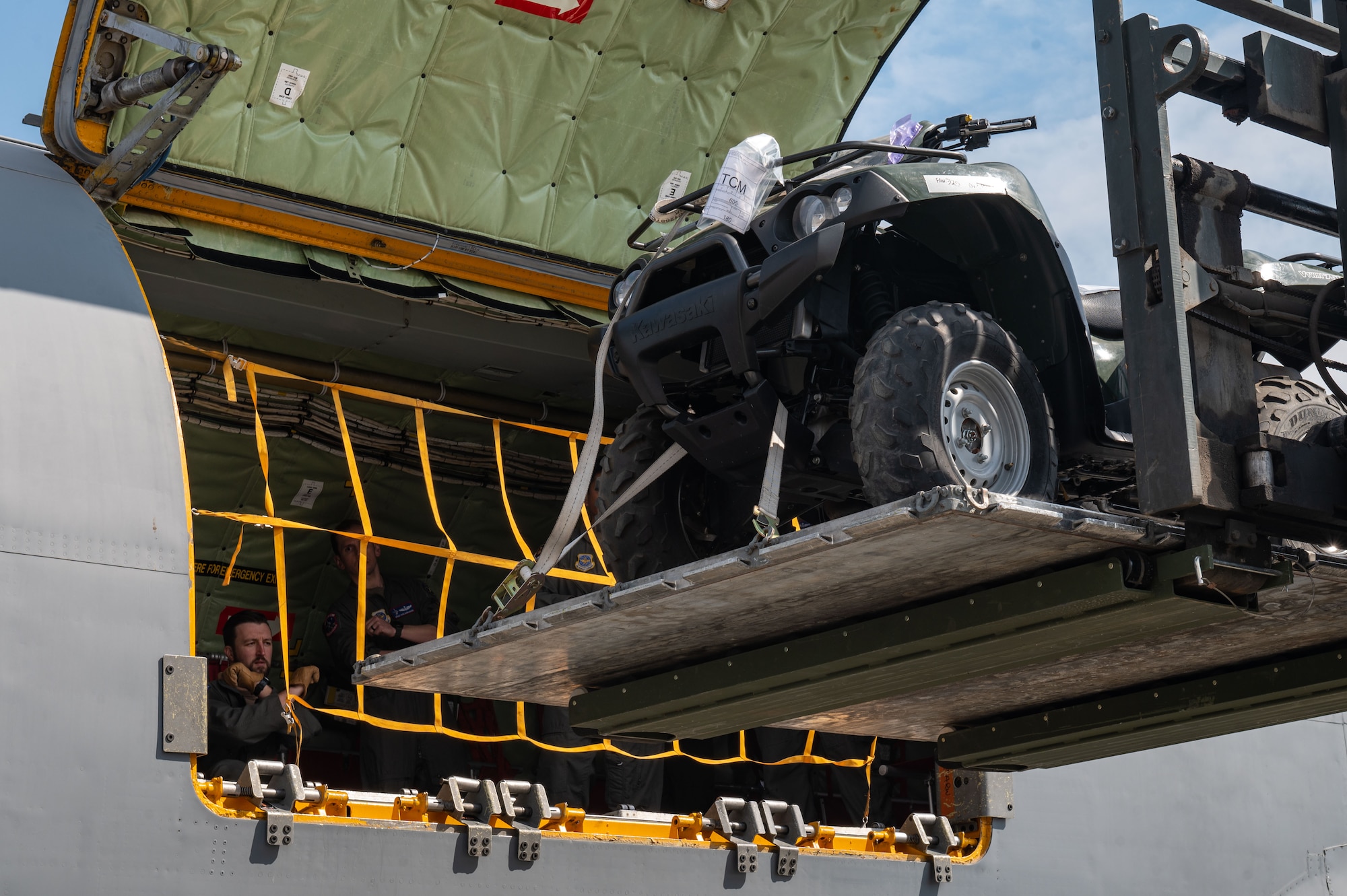 Airmen guide cargo into a KC-135 Stratotanker using a forklift.
