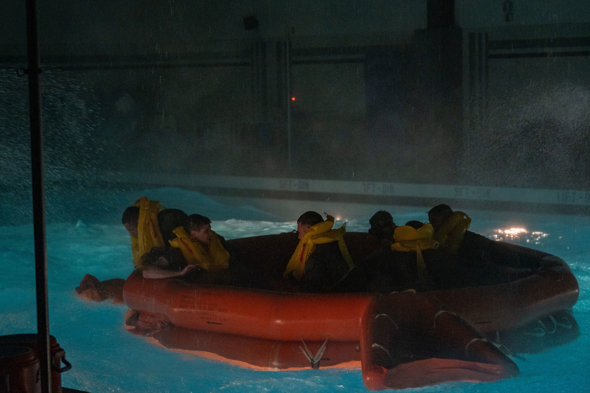 Airmen participate in water survival training in a pool.