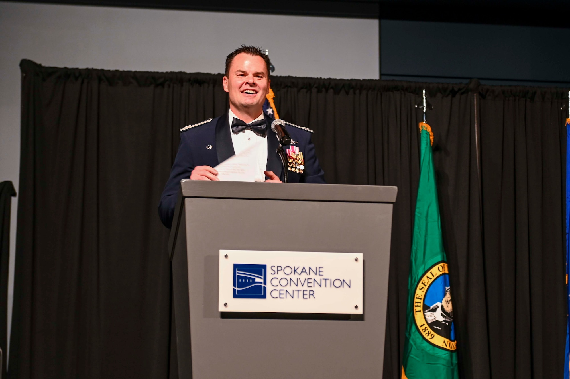 Col. Chesley Dycus delivers a speech from a podium on stage