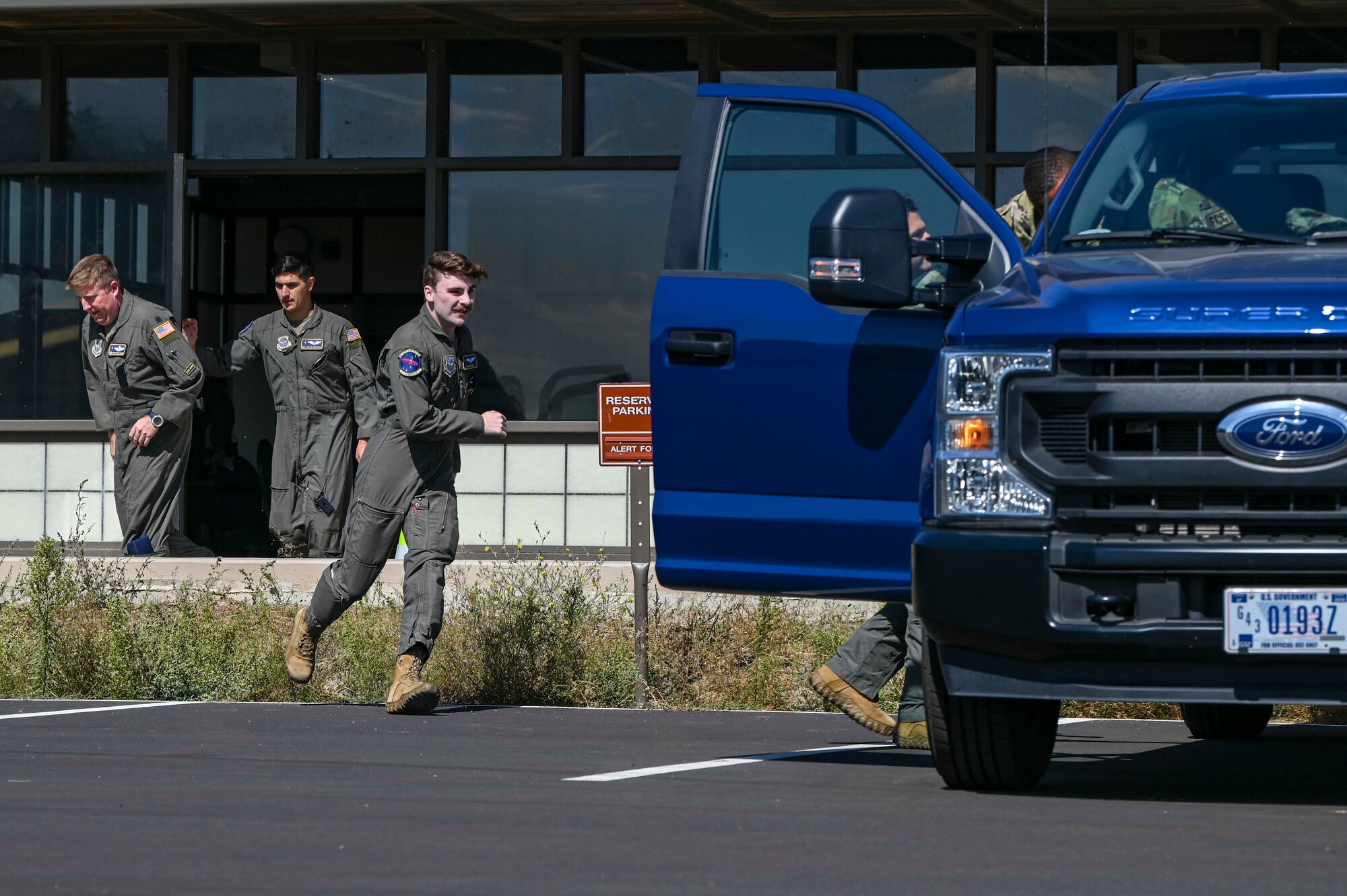 Airmen run to a vehicle on the flightline