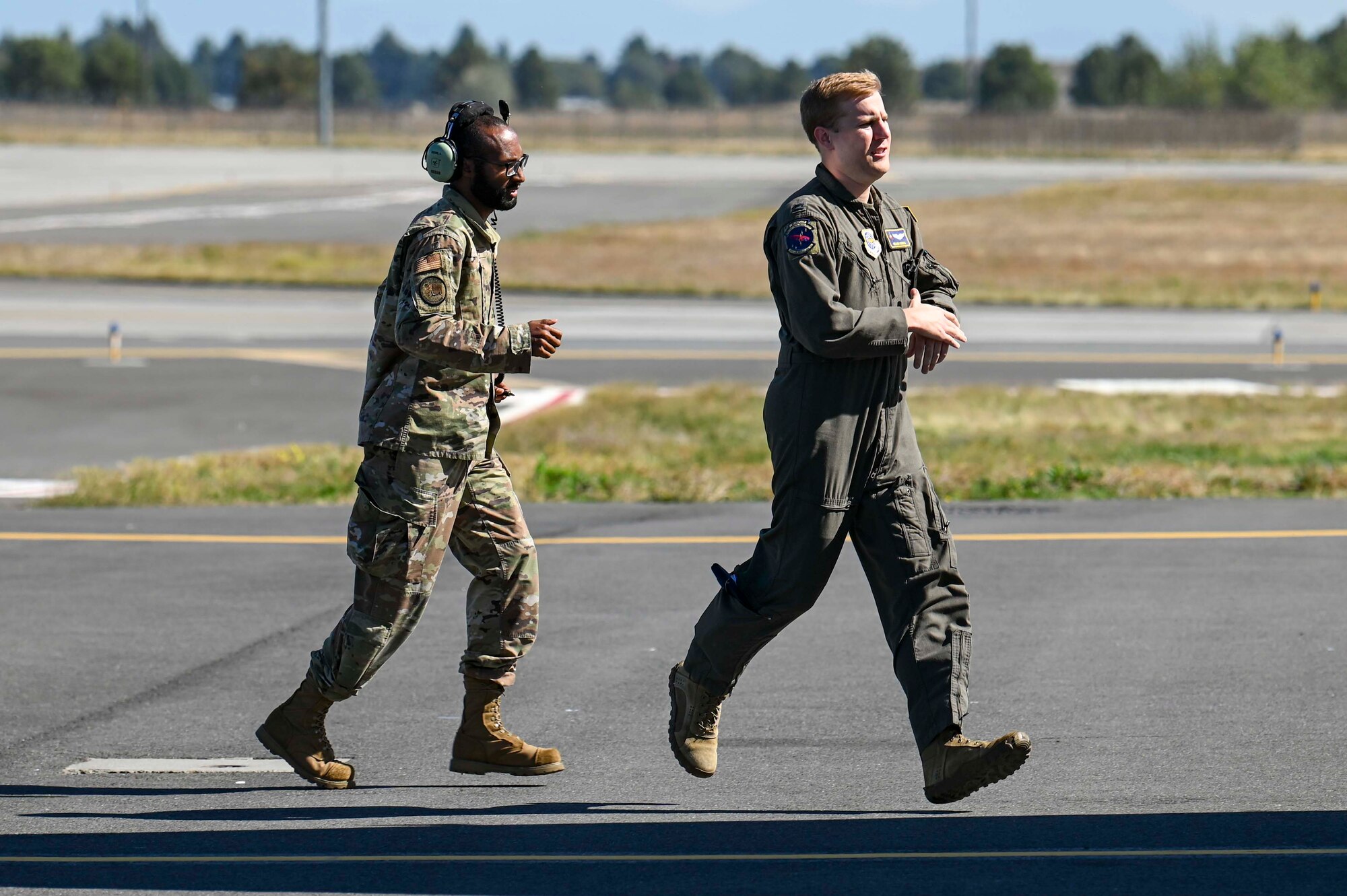 Both Airmen run to a KC-135 Stratotanker