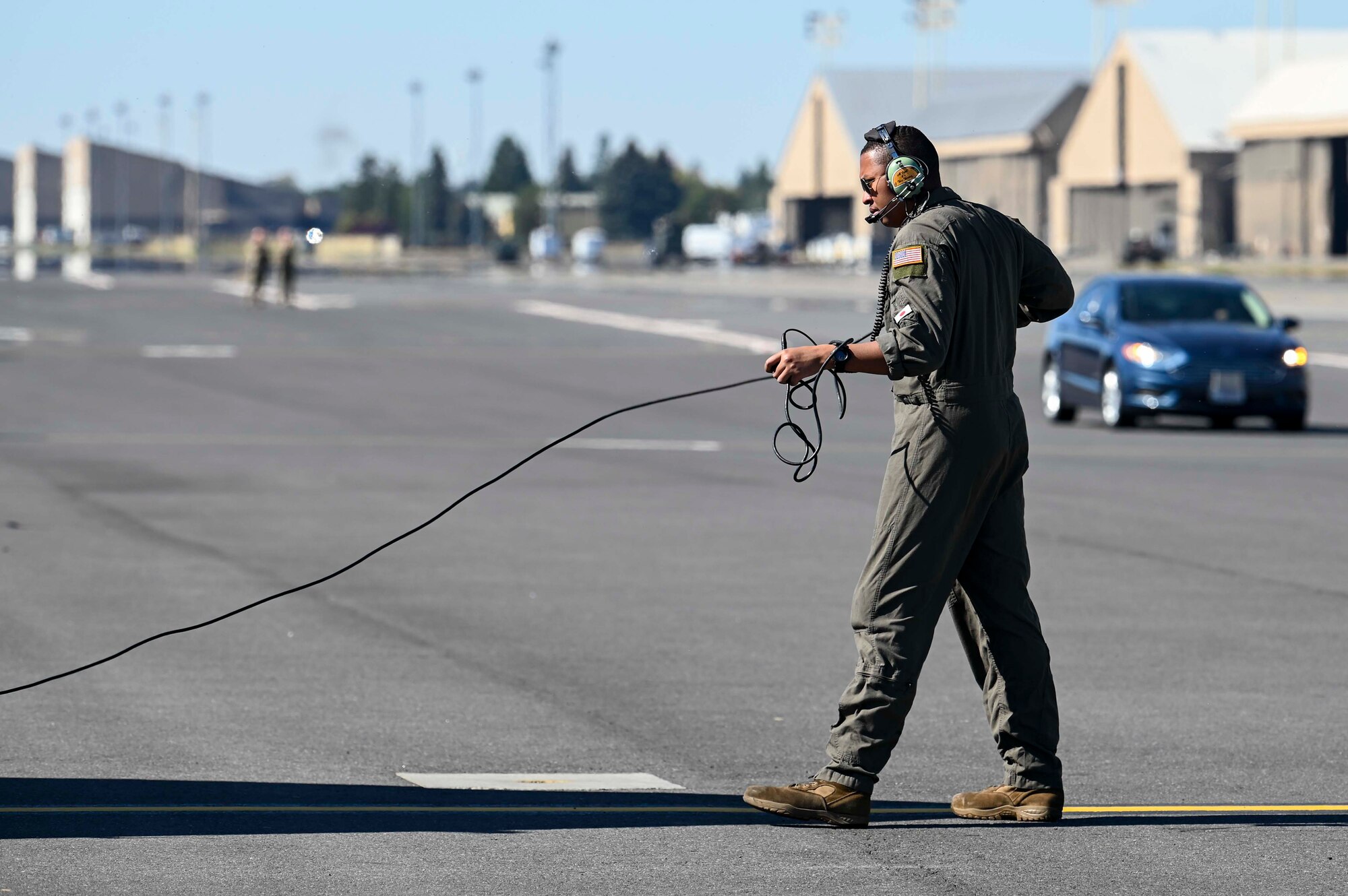 Staff Sgt. Tremal Benton holds the wires to his headset as he communicates with members aboard a KC-135 Stratotanker