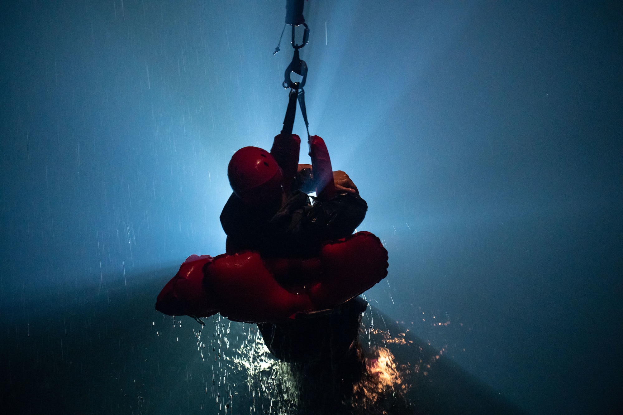 A U.S. Air Force student holds onto a harness during the simulated air lift rescue portion of a water survival course.