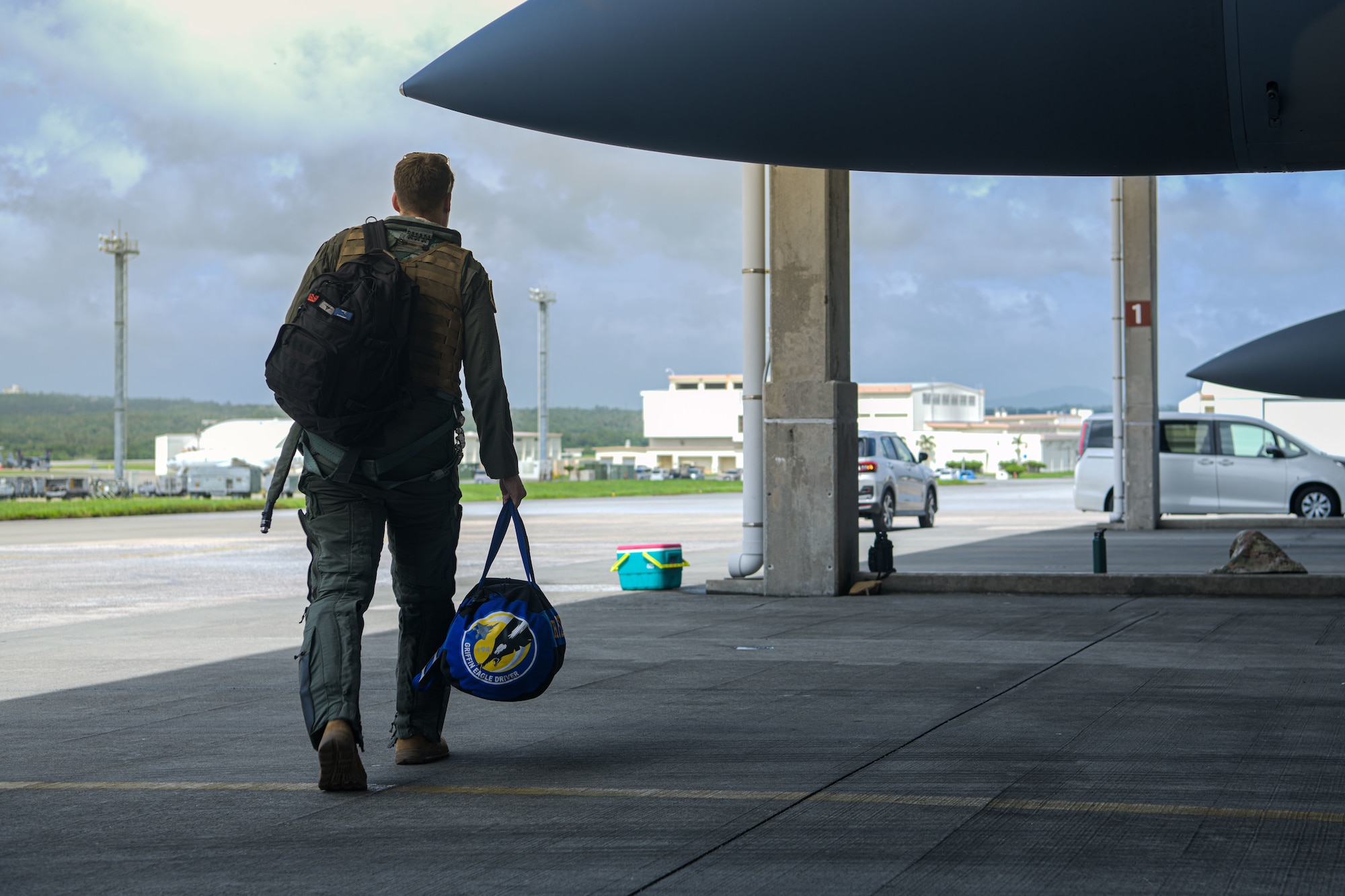 Pilot carries his luggage off the flightline.