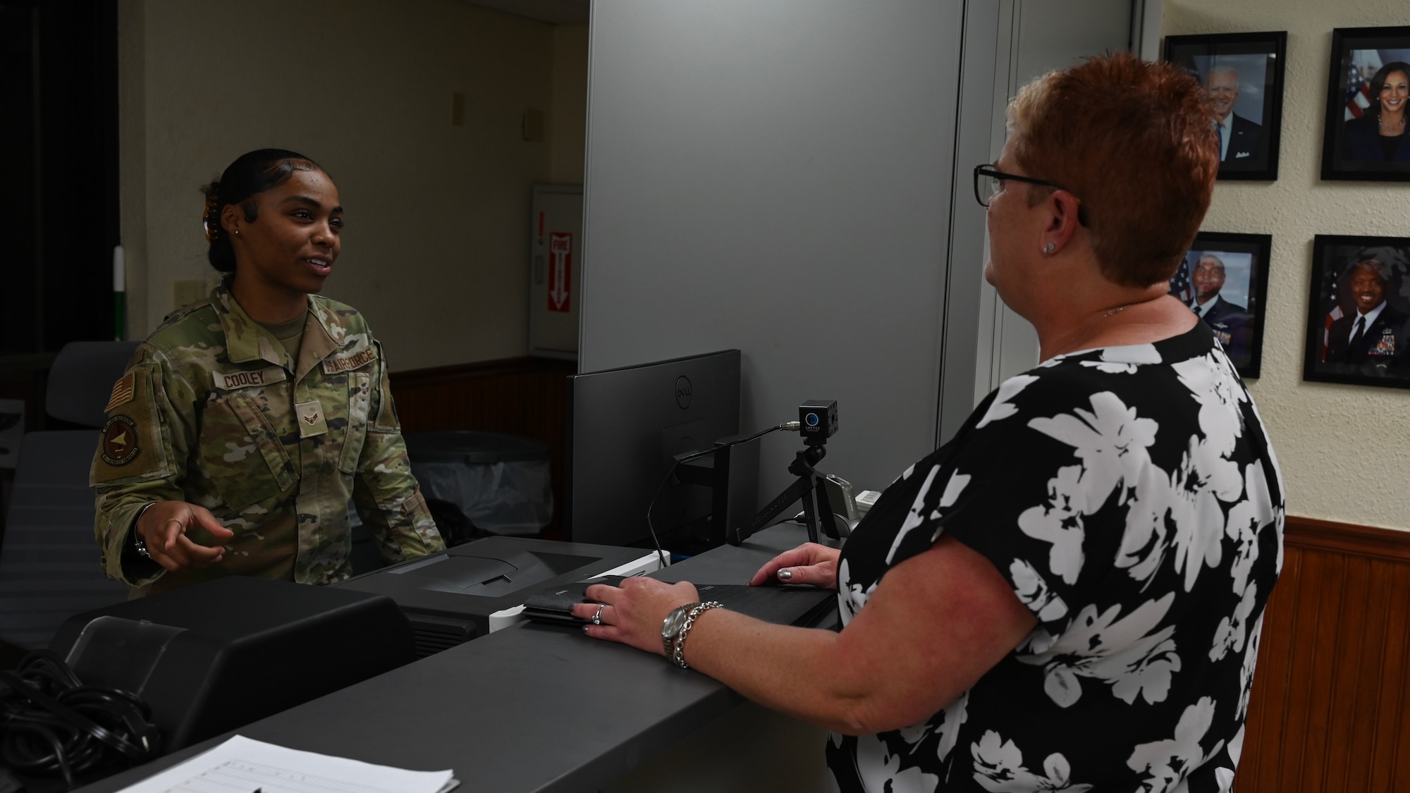 An Airman speaks to a customer about how to get a Defense Biometric Identifications System pass