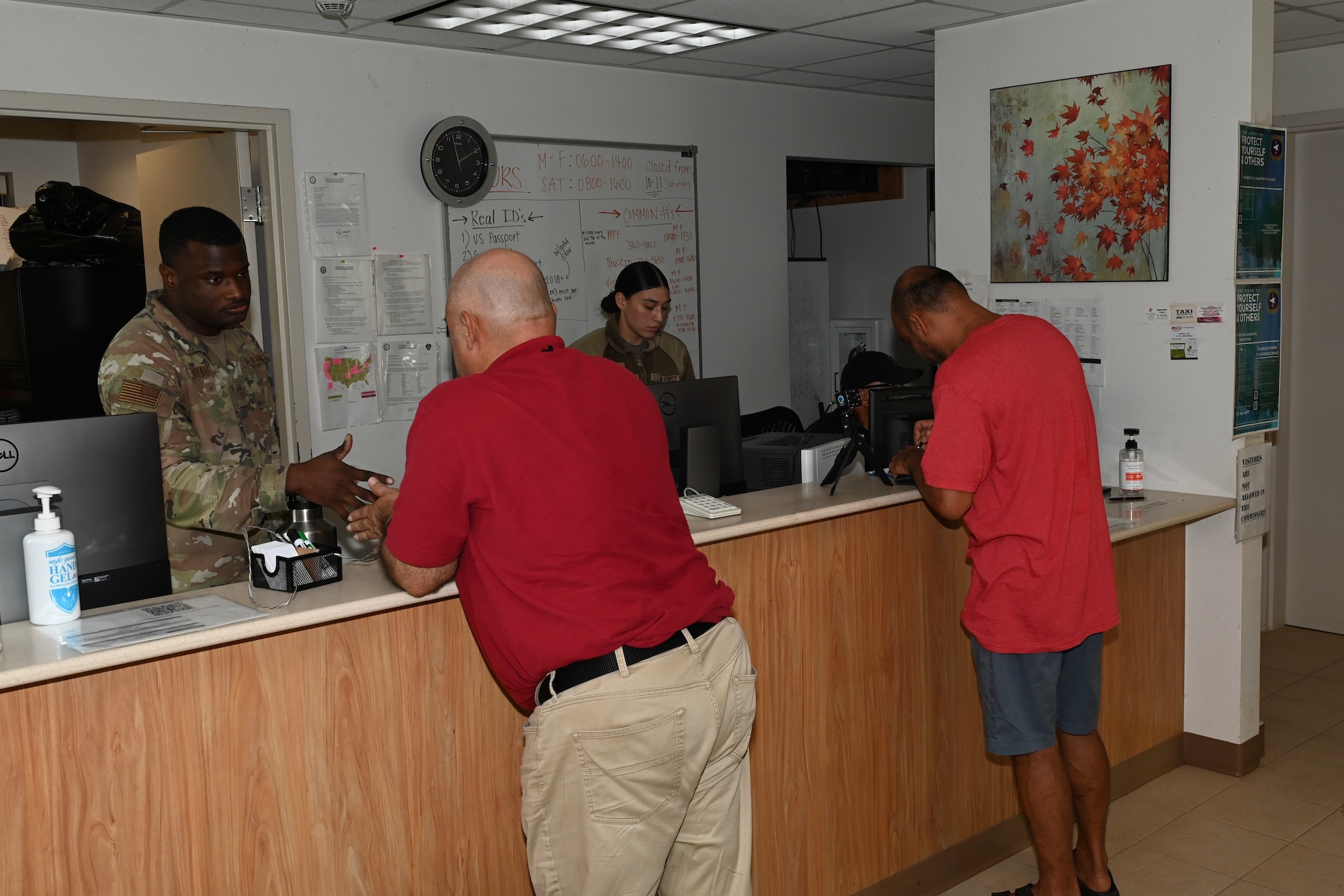 Airmen and government workers help customers with getting a visitors pass.