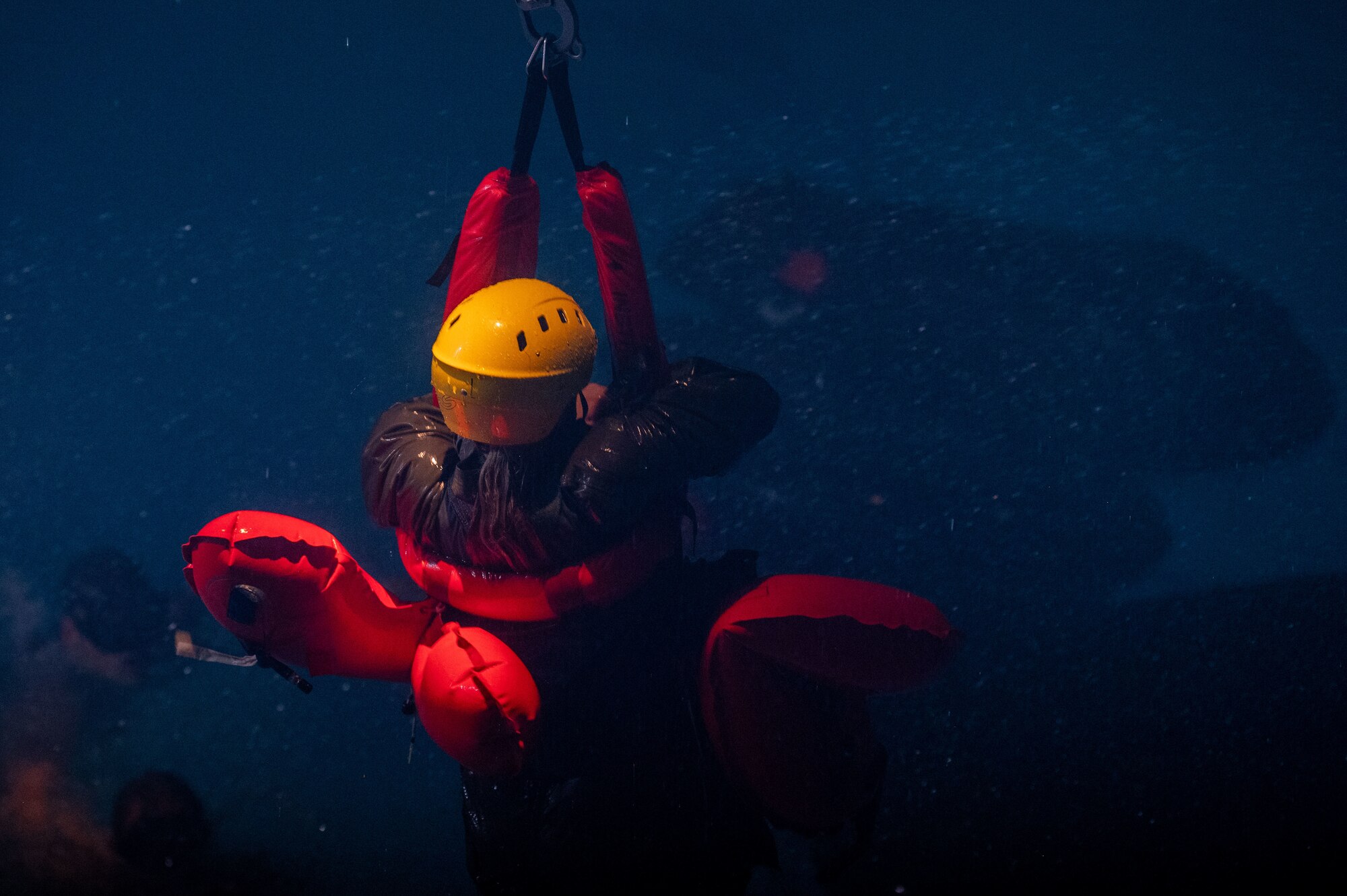 A U.S. Air Force student holds onto a harness during the simulated air lift portion of a water survival course.