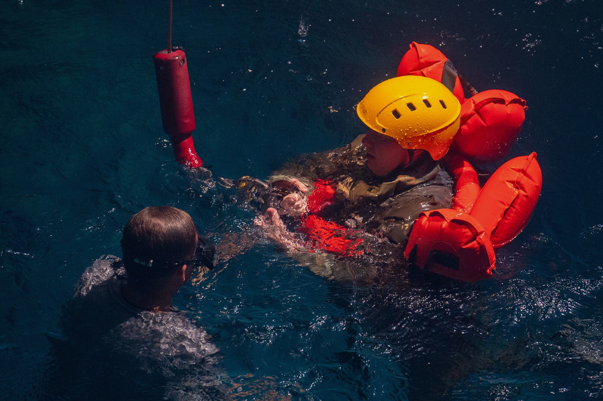 A U.S. Air Force student straps into a harness before the simulated air lift rescue portion of water survival training.