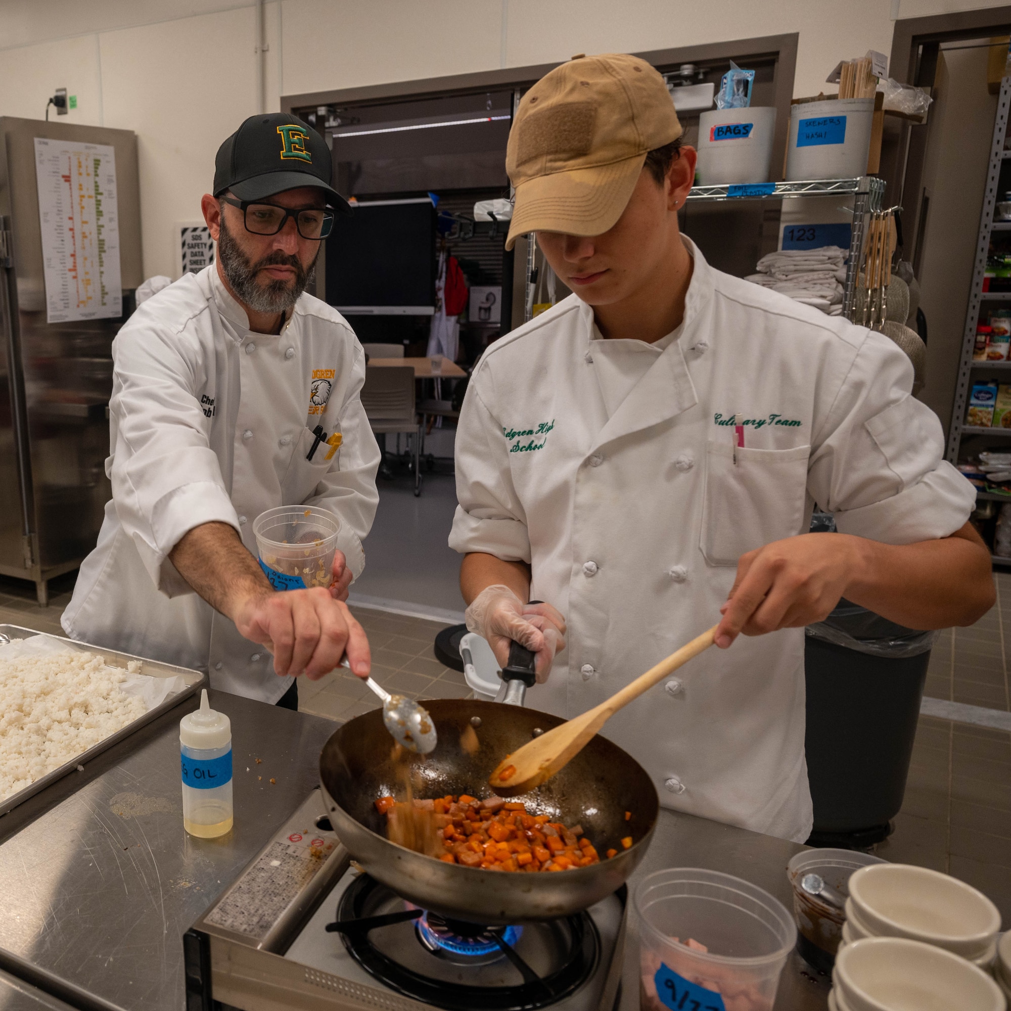 Rob McDonald, Edgren Middle High School culinary instructor, adds spice to a student's dish at Misawa Air Base, Japan, Sept. 24, 2023.