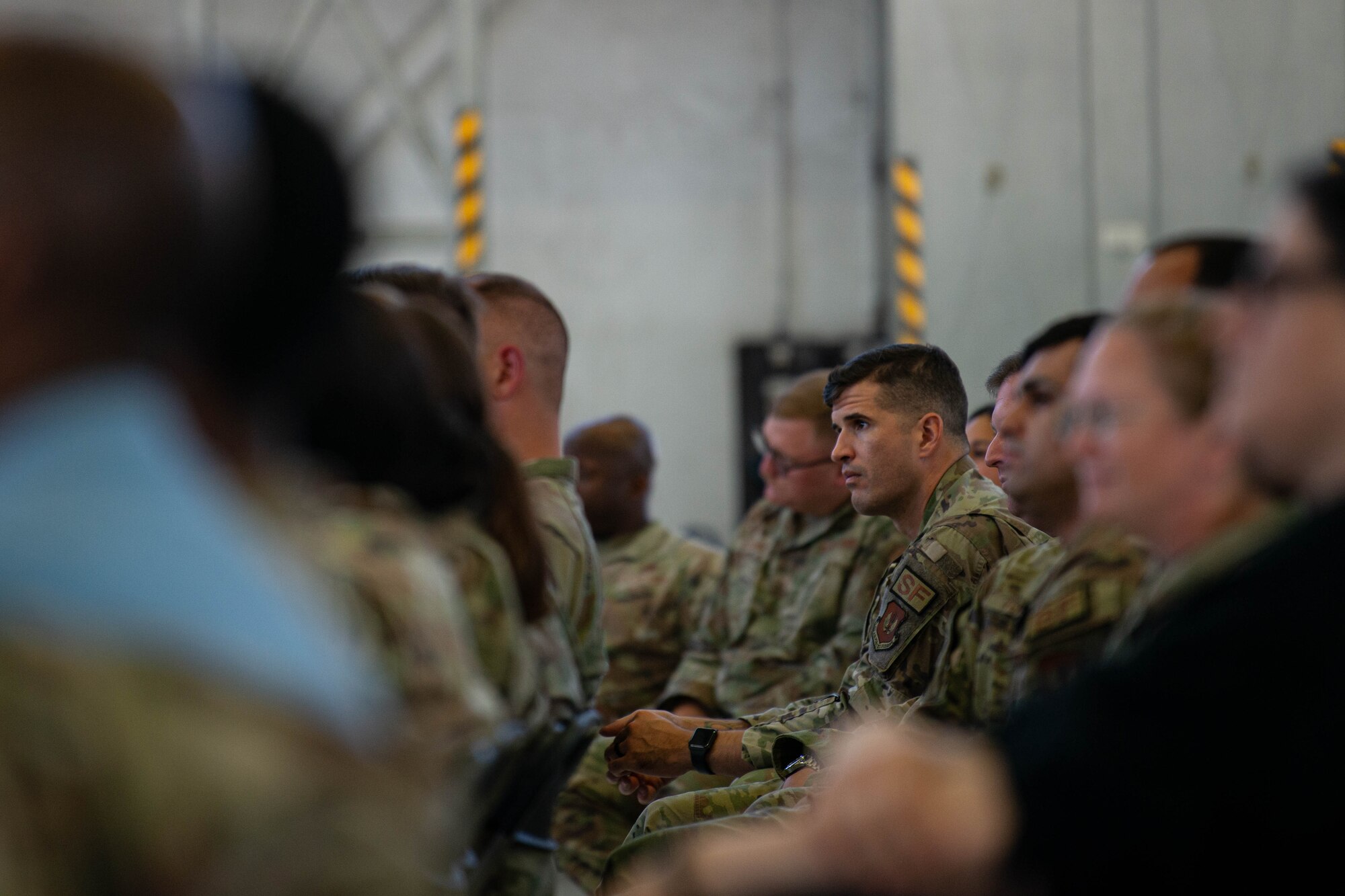 An Airman listens as five speakers share their stories during a storytellers event