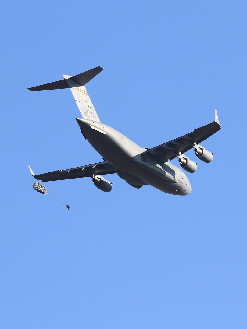 Army paratroopers jump from a C-17 Globemaster III aircraft during