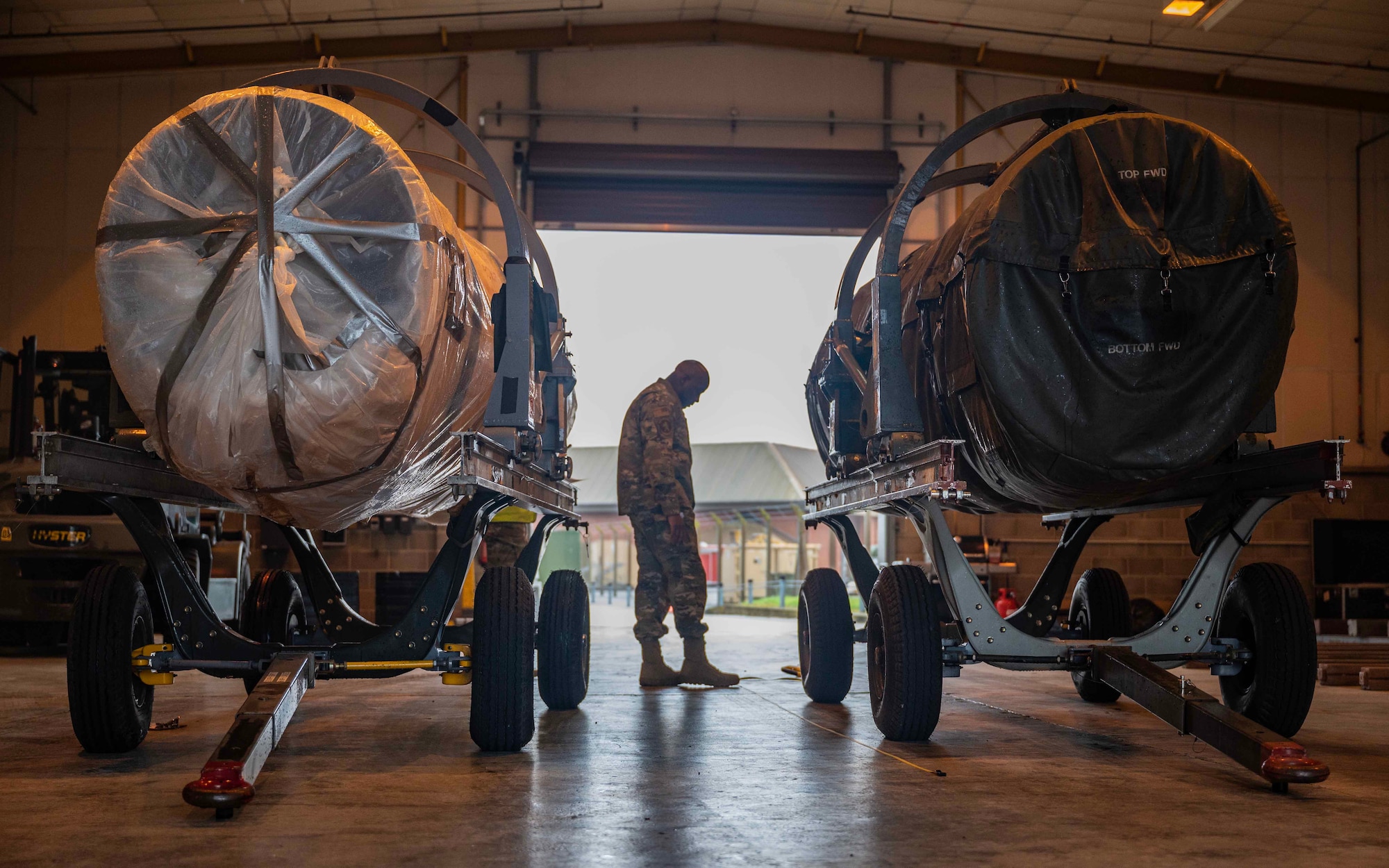 U.S. Air Force Tech. Sgt. Edwin Long, 727th Air Mobility Squadron Air Transportation Function distribution craftsman, inspects mobility cargo from the 480th Fighter Generation Squadron, Spangdahlem Air Base, at Royal Air Force Mildenhall, England, Oct. 3, 2023. RAF Mildenhall AMS and Spangdahlem AFB FGS combat readiness personnel conducted a joint inspection before redeploying the engines by protecting USAF assets, personnel, and maintaining a ready force. (U.S. Air Force photo by Senior Airman Viviam Chiu)
