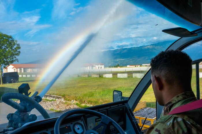 Senior Airman Cash shoots water from the front of a fire truck.