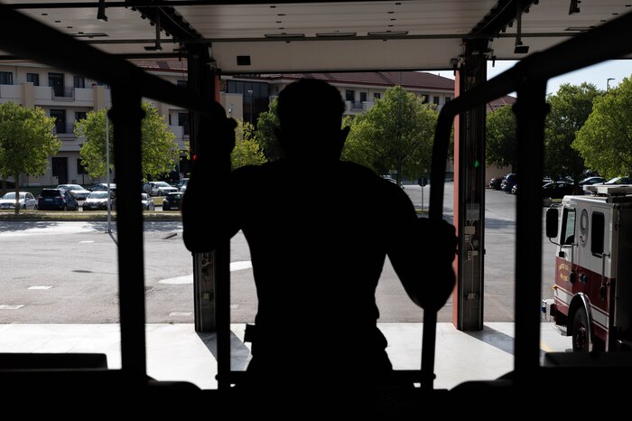 Senior Airman Cash climbs up a fire truck.