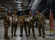 Airmen assigned to the 5th Aircraft Maintenance Squadron pose for a group photo with their certificates and Load Crew of the Year trophy at Minot Air Force Base, North Dakota Oct. 2, 2023. The team earned the award by successfully loading an inert AGM-86 air- launched cruise missile onto a B-52H Stratofortress faster than their competition.