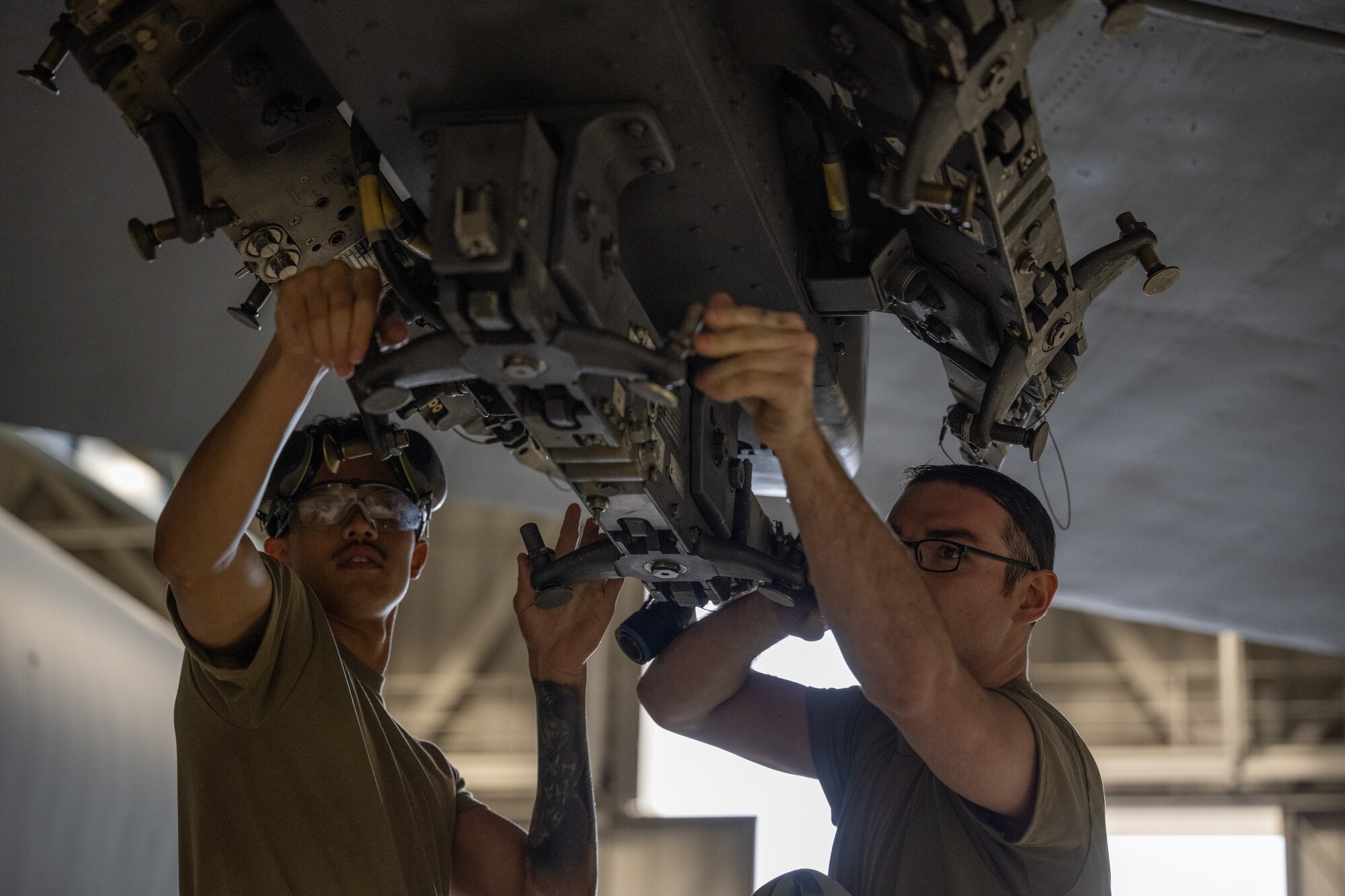 Airman 1st Class Timothy McDonald, 5th Aircraft Maintenance Squadron weapons load crew member (left), and Senior Airman Matthew McMahon, 5th Aircraft Maintenance Squadron weapons load crew member (right), load an inert precision guided munition onto a B-52H Stratofortress at Minot Air Force Base, North Dakota, Oct. 2, 2023. The Airmen competed in the 3rd Quarter Load Crew Competition evaluating their preparedness.