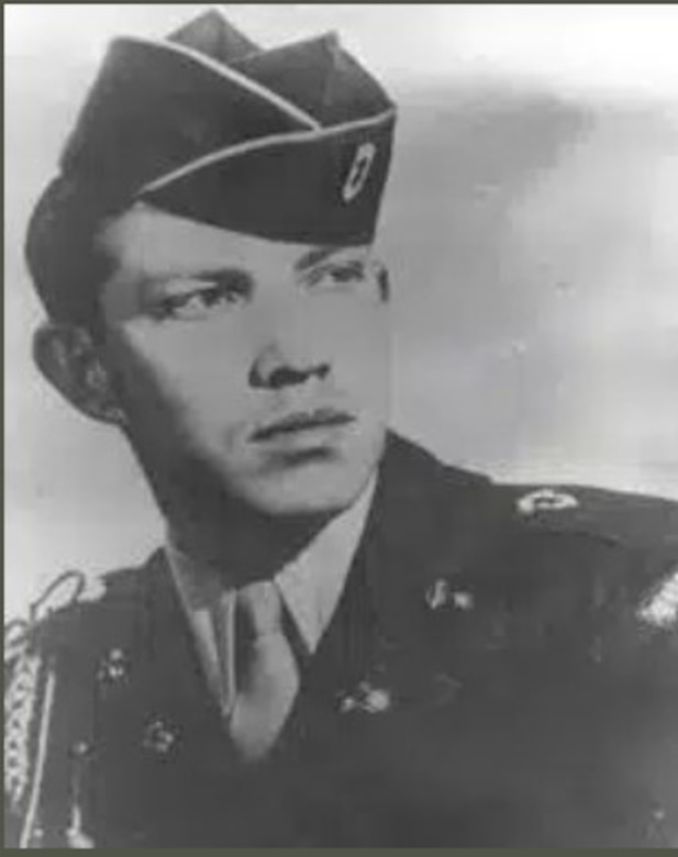 A man in uniform and cap poses for a photo.