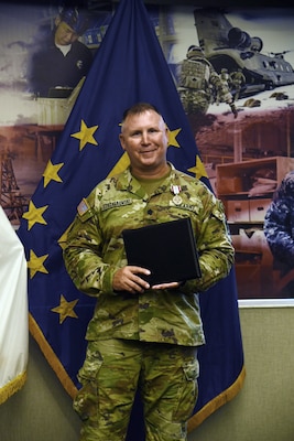 Man in military uniform standing and holding a binder