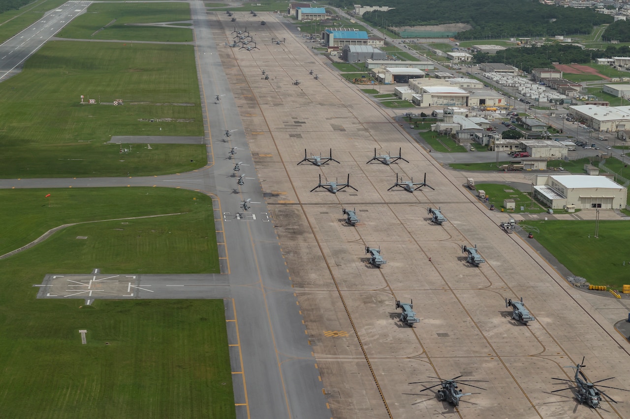 Helicopters taxi on a runway.