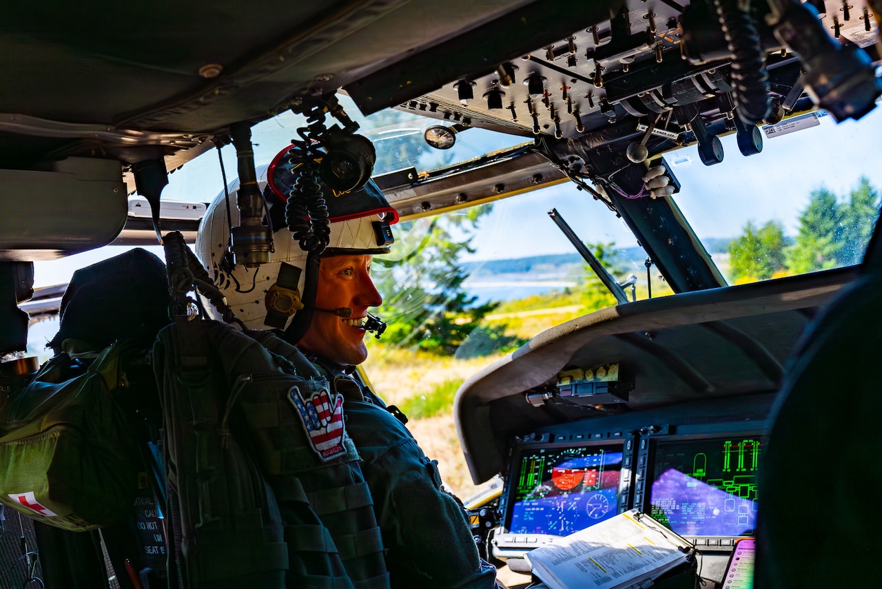 A sailor sits in the cockpit of an aircraft.