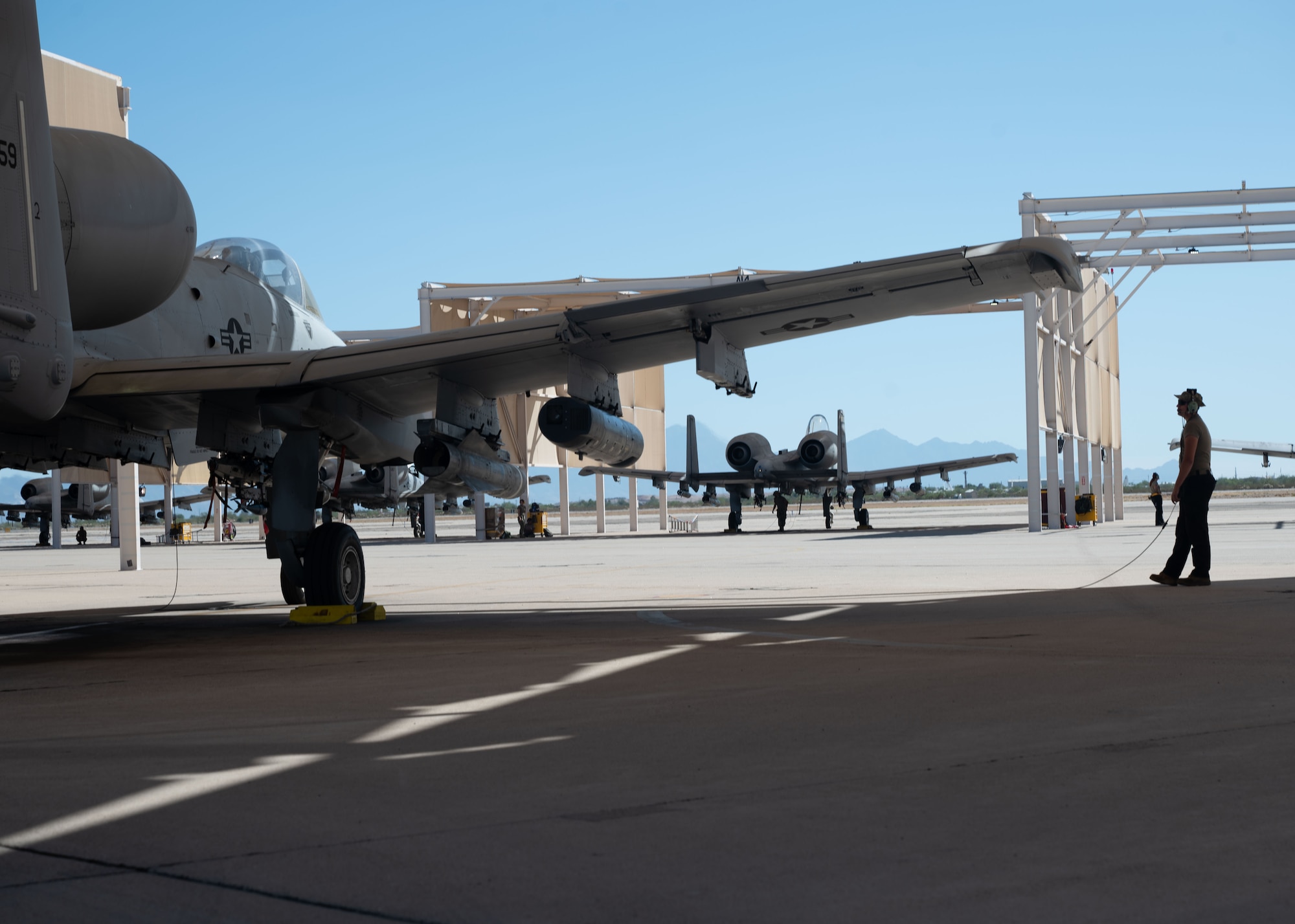 U.S. Air Force Airman 1st Class Sergeant Tanner, 357th Fighter Generation Squadron crew chief, communicates via communication cord by an A-10C Thunderbolt II aircraft as other Airmen prepare aircraft for takeoff on Davis-Monthan Air Force Base, Ariz., Oct 2, 2023. The A-10 can loiter near battle areas for extended periods of time and operate in both low ceiling and low visibility areas. (U.S. Air Force photo by Airman 1st Class Robert Allen Cooke III)