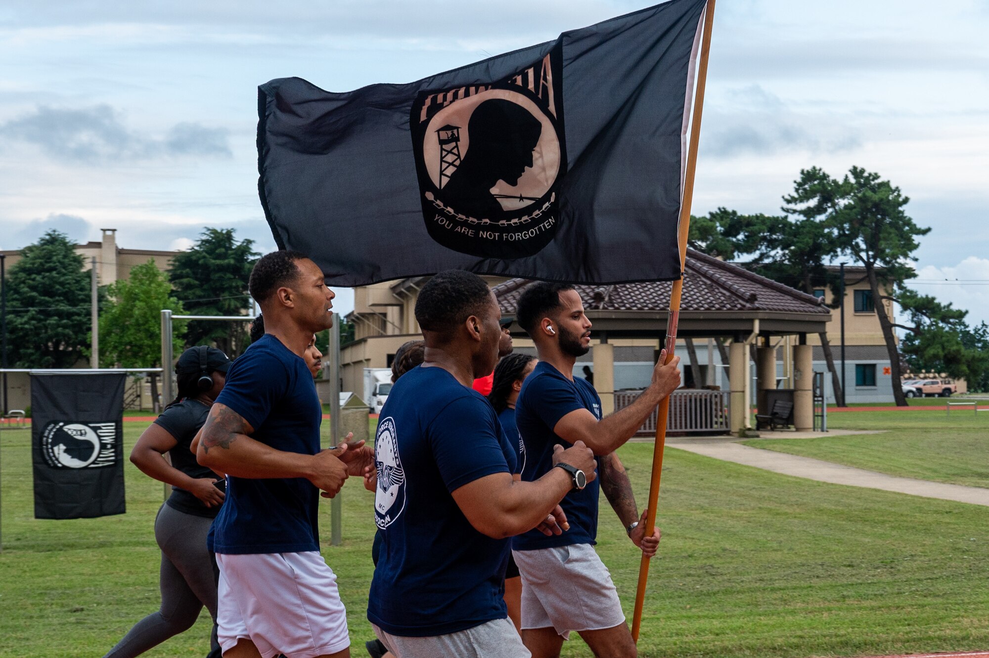Airmen from the 8th Fighter Wing pass the guidon during a 24-hour POW-MIA remembrance run.