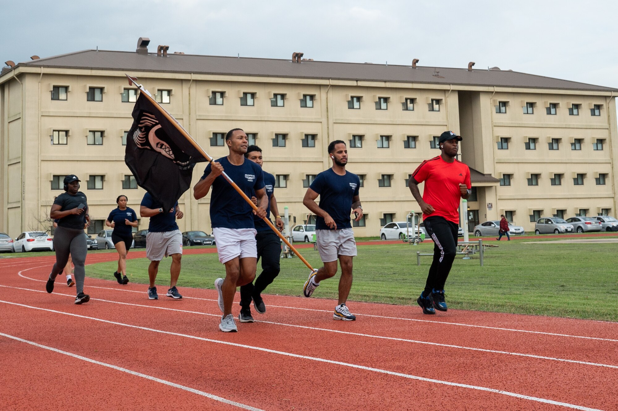Airmen from the 8th Fighter Wing run on a track during a 24-hour POW-MIA remembrance run closing ceremony.