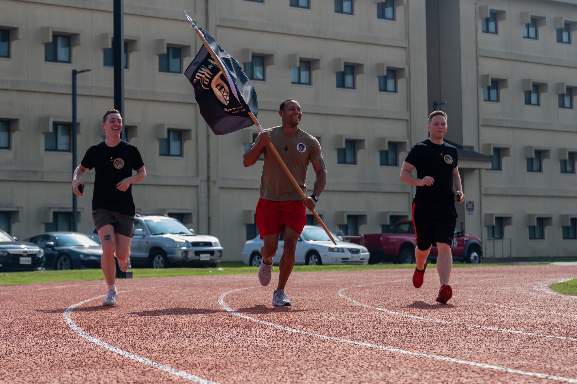Airmen from the 8th Fighter Wing run on a track during a 24-hour POW-MIA remembrance run closing ceremony.
